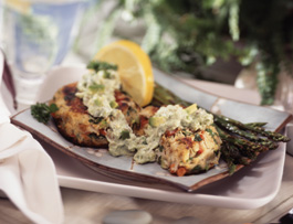 Crab cakes on a plate with lemon and asparagus.