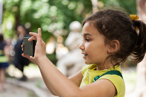 Girl taking a photo with a smart phone.