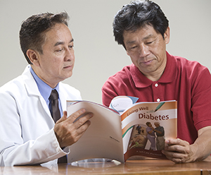 Man and doctor looking at Diabetes Workbook.
