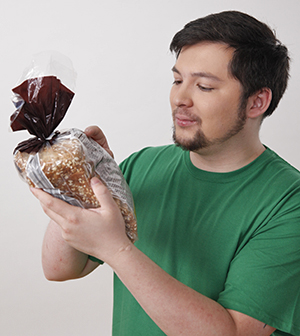 Man reading nutrition label on package of bread.